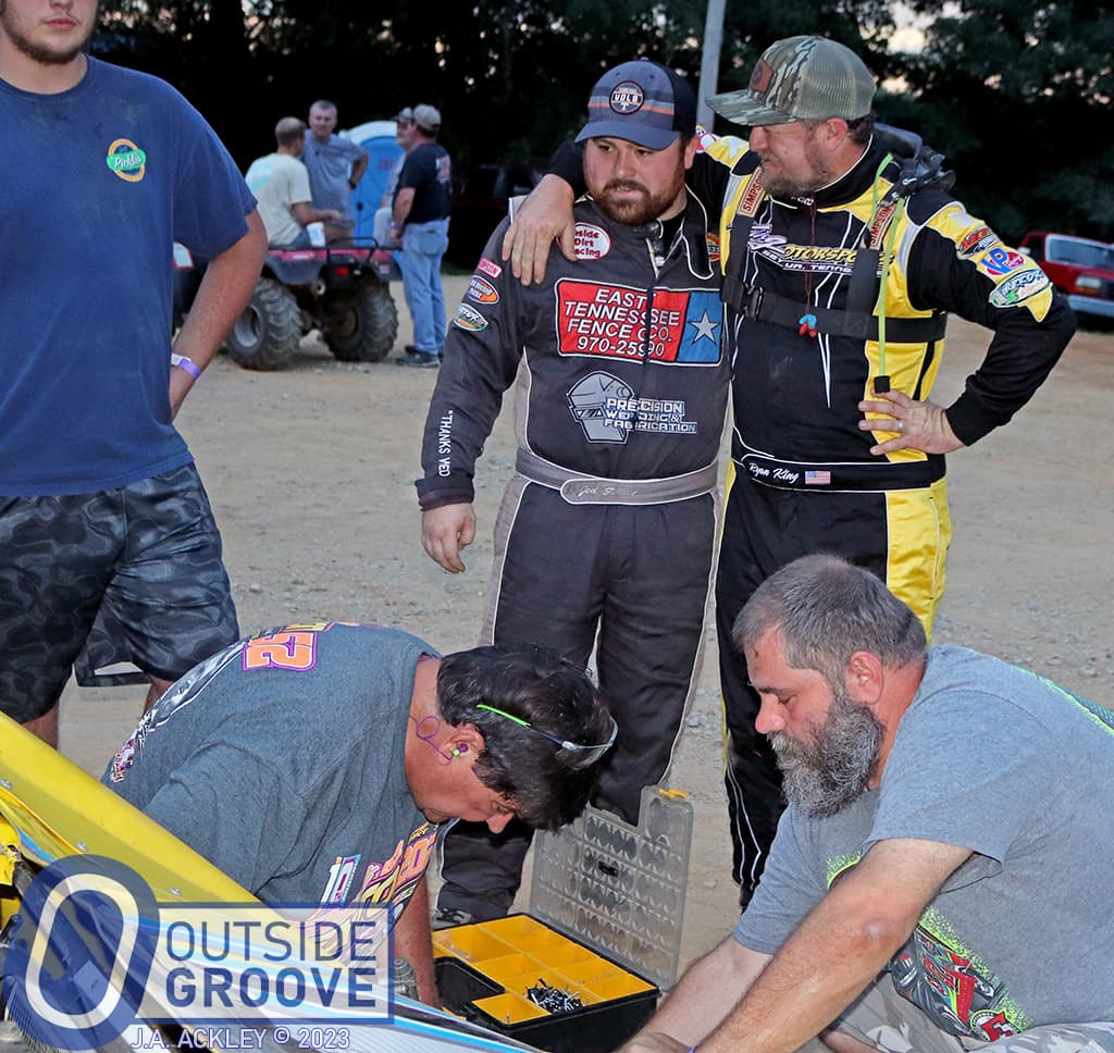 Ryan King and Jed Emert in the pits assessing damage to the car with the crew